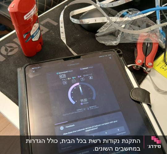 מד מהירות אינטרנט, כבלים וכלים על שולחן עבודה